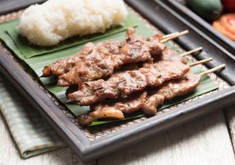 Thai styled grilled pork and sticky rice on wood
