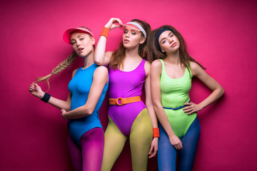 portrait of sporty women in fitness clothing on pink
