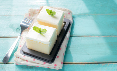 Milk cake delicious on the wood table with shadows from a window frame