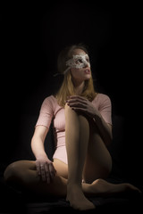Teenage girl wearing lace mask on black background