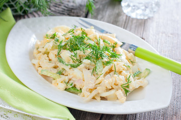 Salad with squid, egg and rice on a white plate, selective focus,horizontal