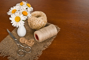 Fototapeta na wymiar Scissors, cord and flower in vase