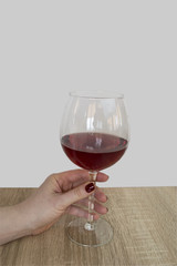 Red wine in a glass in the hand on the table