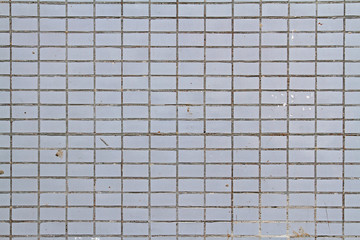 Mosaic tiles on the facade of a house. Architectural background made of grey mosaic wall