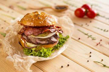 Meat burger with pickled cucumber and bacon