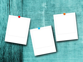Three blank square photo frames on aqua wooden boards background