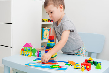 Child hands collect wooden puzzle