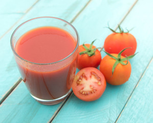 Glass of tomato juice on blue wooden table