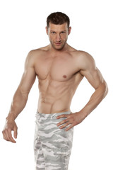 Fototapeta premium half-naked handsome and muscular young man posing on a white background