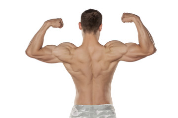 rear view of the half-naked handsome and muscular young man posing on a white background