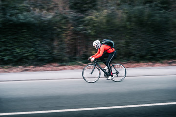 Schneller Radfahrer/Mann fährt mit Rennrad bergab