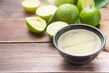 freshly squeezed lime juice with lime fruits on wood table
