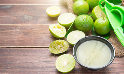 freshly squeezed lime juice with lime fruits on wood table
