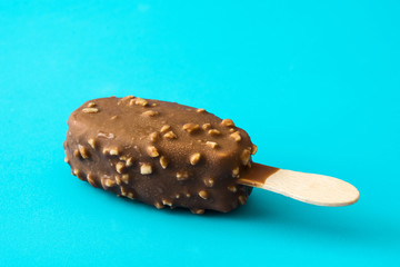 Chocolate ice cream popsicle isolated on blue background. 
