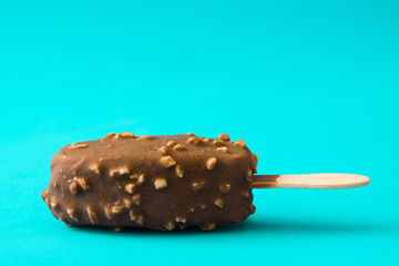 Chocolate ice cream popsicle isolated on blue background. 
