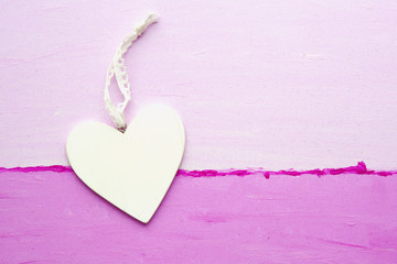 white wooden heart on a pink canvas
