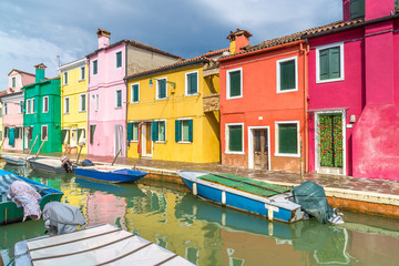 Fototapeta na wymiar Colorful houses on Burano. A typical street and canal on the island of Burano near Venice.