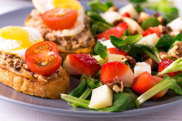 Salad with strawberry, spinach and goat cheese.  Bruschettes