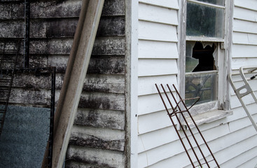Obraz premium Corner of old house with unpainted wall and broken window
