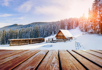 winter mountains landscape with a snowy forest and  wooden hut