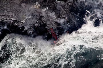 Glühende Lava fliesst ins Meer an der Südküste von Big Island, Hawaii, USA.