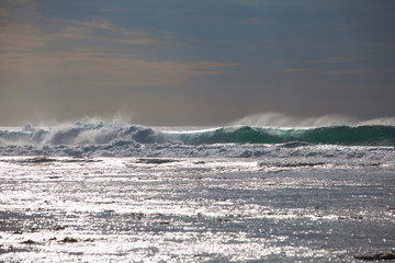 Ocean waves close up and the sparkle of water at sunset
