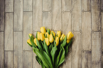 Yellow tulips on brown background in the form of stylish tiles