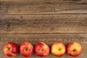 Red apples on the old wooden table.