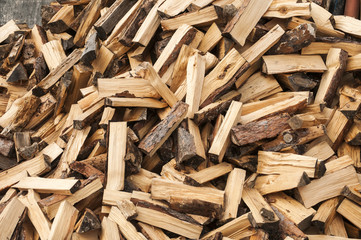 Pile of cut and cleaved firewood closeup as background