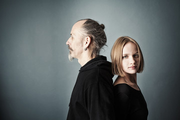 Man and woman stand with their backs to each other