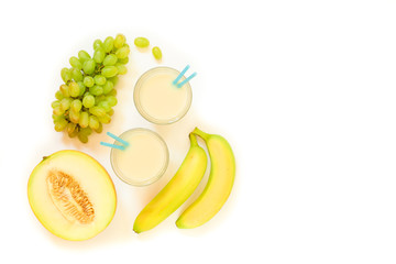 Two glasses of melon, grapes, banana juice isolated on white.
