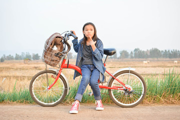 Happy girl with bicycle on grass field, selective and soft focus, concept travel in holiday