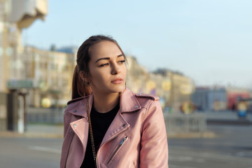 Obraz premium Fashion portrait of a beautiful girl who looks at the setting sun