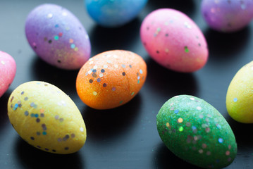 Colored eggs on black background,