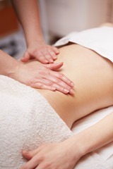 Fototapeta na wymiar A woman receiving a belly massage at spa salon