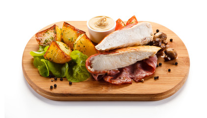 Grilled chicken fillet served on cutting board