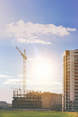 Fototapeta premium Construction crane and a building house. Sky,clouds,sunlight