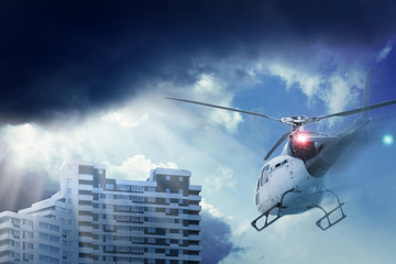 Rotor helicopter fly to the building. Beautiful overcast sky with clouds and sunlight