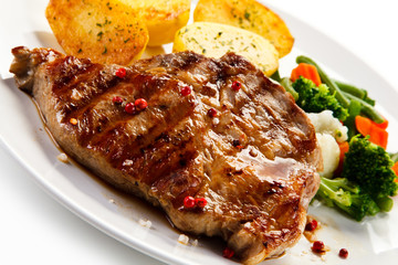 Steaks, baked potatoes and vegetable salad