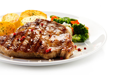 Steaks, baked potatoes and vegetable salad