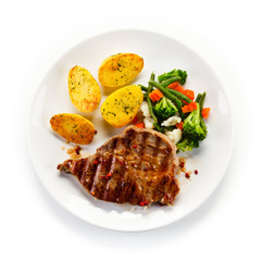 Steaks, baked potatoes and vegetable salad