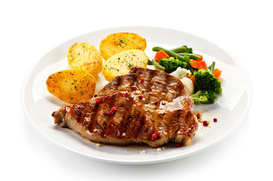 Steaks, baked potatoes and vegetable salad