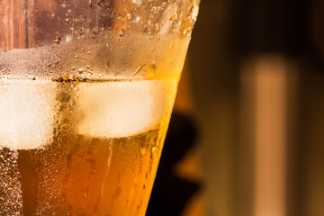 Glass of whiskey with ice cubes  on blurred background. Close up