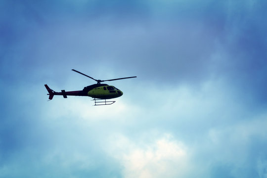 Rotor helicopter flying against the blue sky background