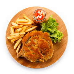Fried pork chop with french fries on cutting board