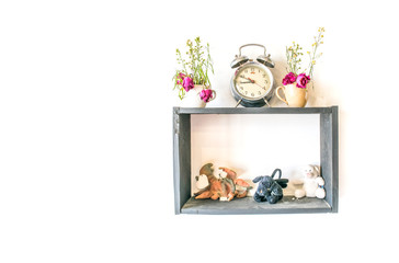 small doll and clock with flower pot decoration on wood frame isolated white background

