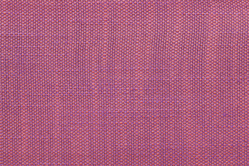 Magenta textile background with checkered pattern, closeup. Structure of the fabric macro.