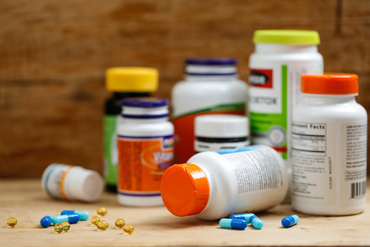 Medicine bottles and tablets on wooden desk