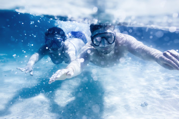 Couple swims or snorkeling underwater