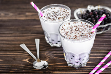 Homemade milkshake with berries on wooden background